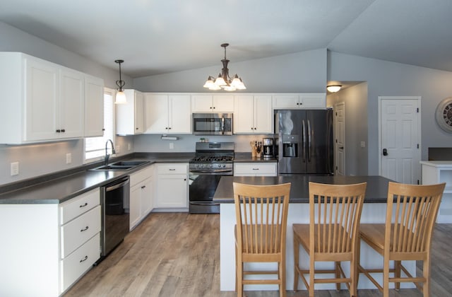 18885 Maryville Rd, Brainerd, MN 56401 - kitchen with stainless steel appliances, dark countertops, a sink, a chandelier, and lofted ceiling