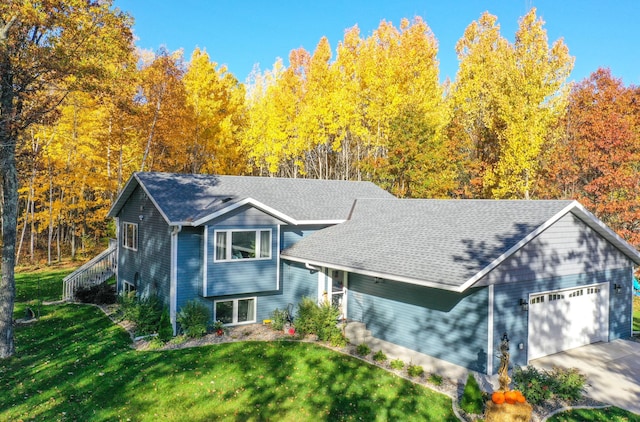 18885 Maryville Rd, Brainerd, MN 56401 - split level home featuring an attached garage, a front yard, a shingled roof, and concrete driveway