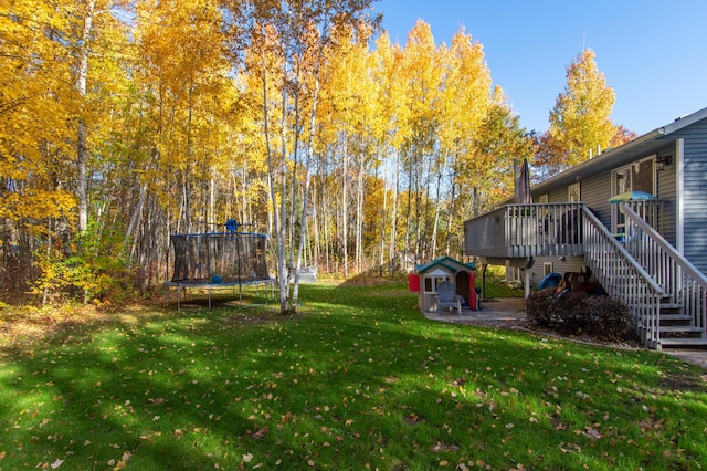18885 Maryville Rd, Brainerd, MN 56401 - view of green lawn with a trampoline, stairway, and a deck