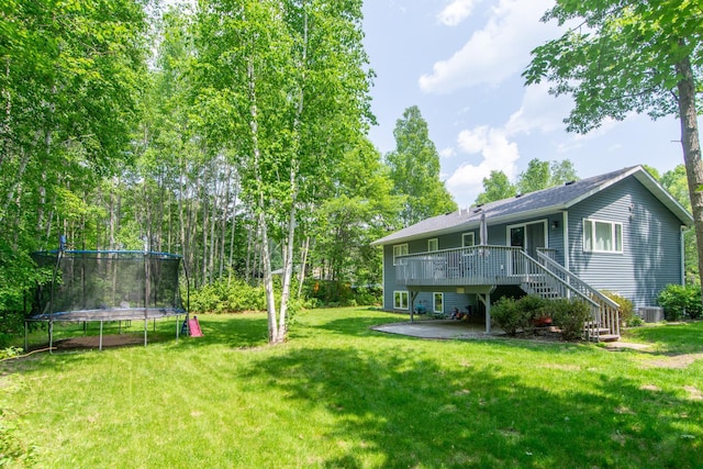 18885 Maryville Rd, Brainerd, MN 56401 - view of green lawn with a trampoline, a wooden deck, stairs, and central air condition unit