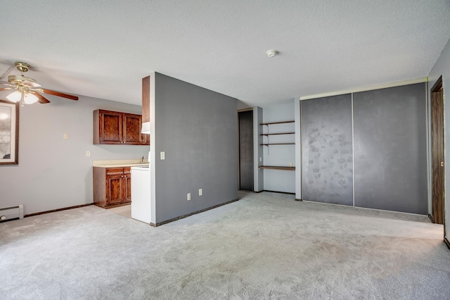 702 Old Settlers Trl Unit 3, Hopkins, MN 55343 - unfurnished living room with a ceiling fan, light colored carpet, a textured ceiling, and a baseboard radiator