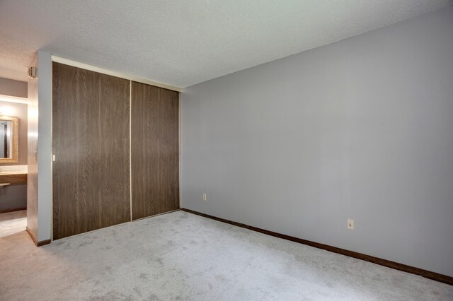 702 Old Settlers Trl Unit 3, Hopkins, MN 55343 - unfurnished bedroom featuring carpet, a closet, and a textured ceiling