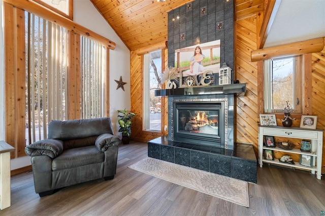 4463 Singkoffer Rd, Summit Twp, WI 54880 - living room featuring lofted ceiling, wood finished floors, a tiled fireplace, and wood walls