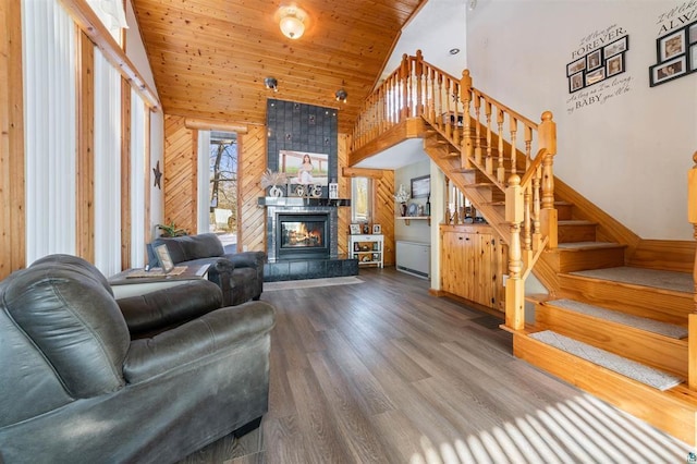4463 Singkoffer Rd, Summit Twp, WI 54880 - living room with wooden walls, stairway, high vaulted ceiling, a tiled fireplace, and wood ceiling