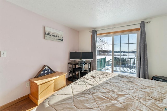 4463 Singkoffer Rd, Summit Twp, WI 54880 - bedroom featuring access to outside, a textured ceiling, and wood finished floors