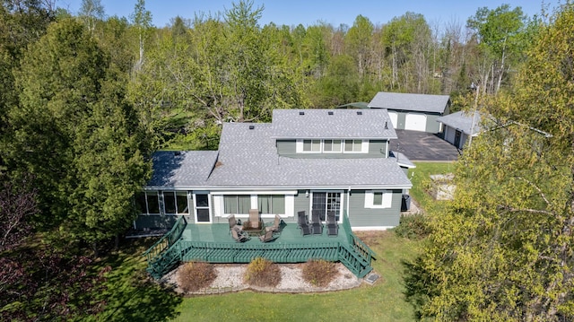 4463 Singkoffer Rd, Summit Twp, WI 54880 - rear view of house featuring a deck, a shingled roof, a view of trees, and a yard