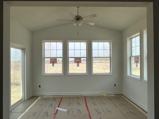 unfurnished room featuring baseboards, a ceiling fan, and vaulted ceiling