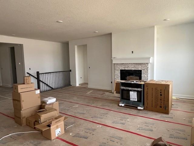 unfurnished living room with a fireplace and a textured ceiling