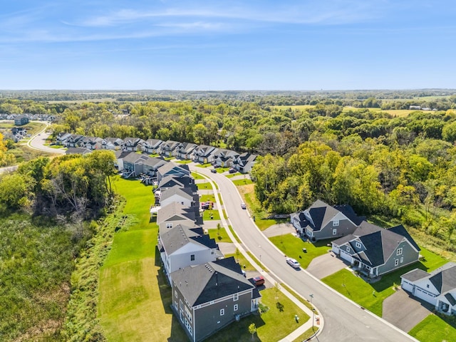 drone / aerial view featuring a residential view and a forest view