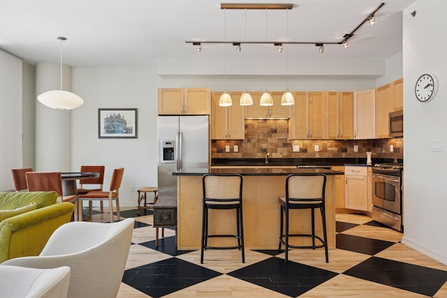 215 10th Ave S Unit 633, Minneapolis, MN 55415 - kitchen with appliances with stainless steel finishes, light brown cabinetry, dark countertops, and decorative backsplash