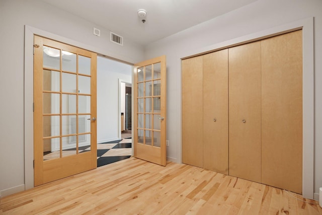 215 10th Ave S Unit 633, Minneapolis, MN 55415 - unfurnished bedroom with french doors, wood finished floors, and a closet