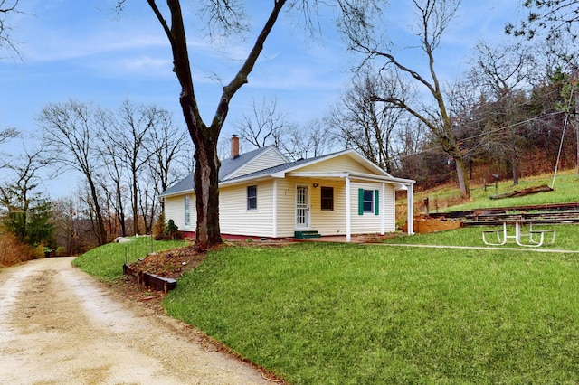 bungalow-style home featuring a porch, a chimney, and a front yard