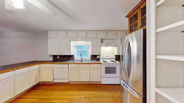 kitchen featuring light wood-style flooring, a sink, ceiling fan, under cabinet range hood, and white appliances