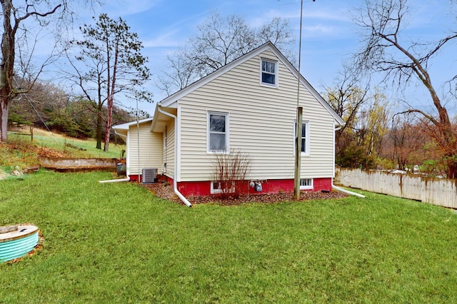 view of property exterior featuring fence, a yard, and central air condition unit