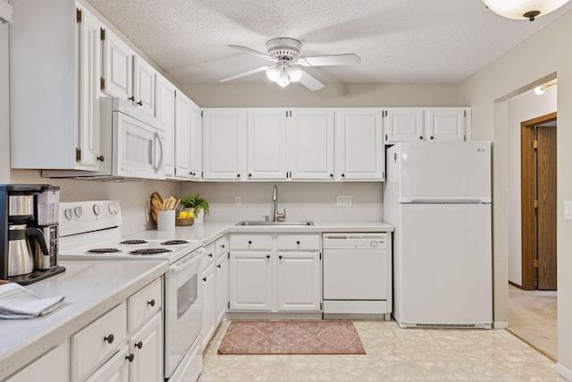 kitchen with white appliances, ceiling fan, light countertops, white cabinets, and a sink