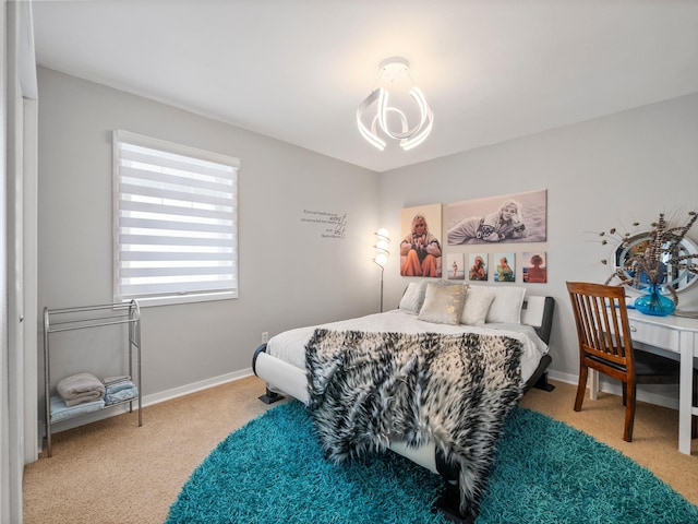 bedroom with a chandelier, baseboards, and carpet