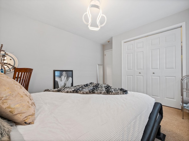 bedroom featuring a chandelier, a closet, and light colored carpet