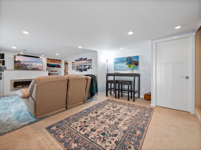 living area with recessed lighting, a warm lit fireplace, and carpet floors