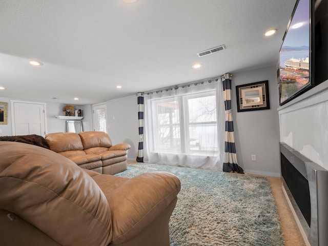 living area featuring baseboards, light carpet, a fireplace, recessed lighting, and visible vents