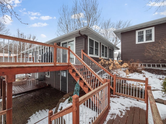 snow covered deck featuring stairway