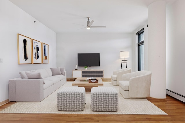 living room featuring a baseboard radiator, ceiling fan, and wood finished floors