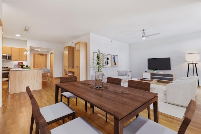 dining room featuring light wood-style floors and a ceiling fan