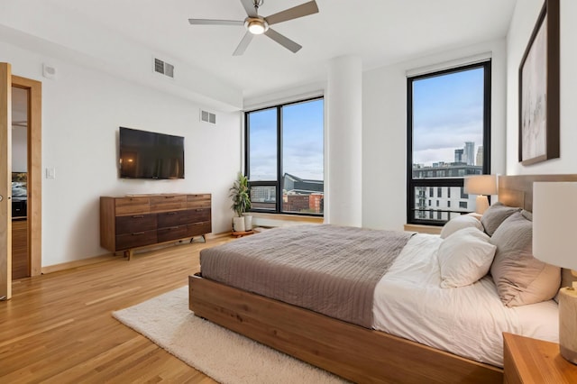bedroom with visible vents, light wood finished floors, and multiple windows