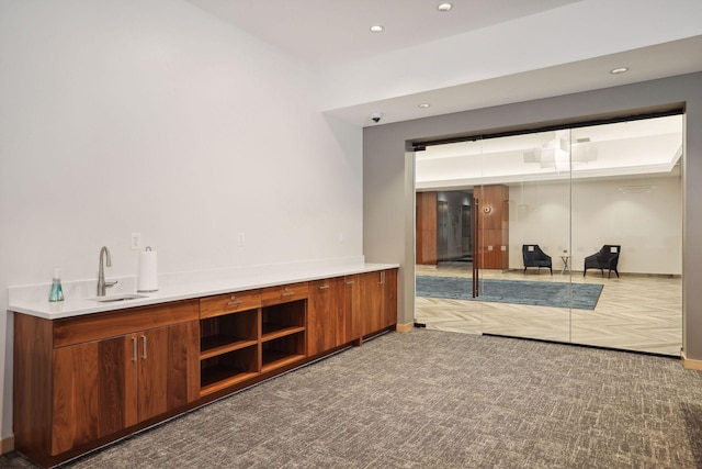 bar with recessed lighting, a sink, carpet, and baseboards