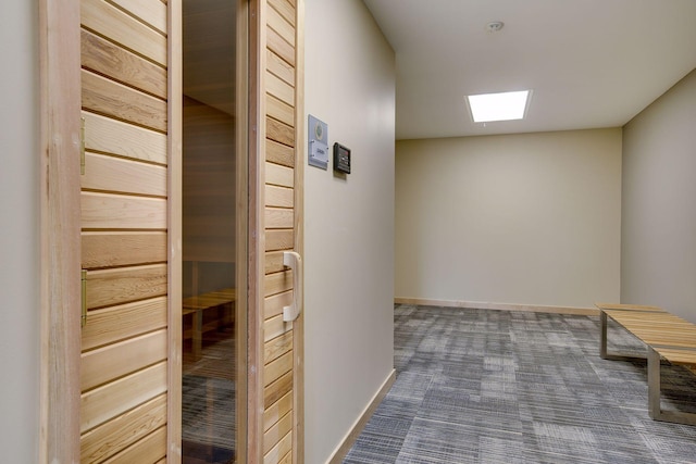 hall with a skylight, baseboards, a sauna, and dark carpet