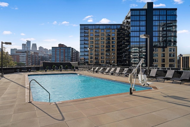 community pool featuring a view of city and a patio area