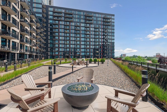 surrounding community featuring fence, a patio, and an outdoor fire pit