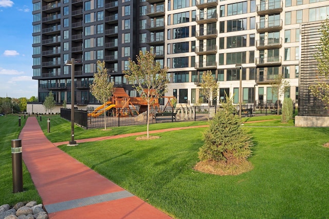 view of community with a lawn and fence
