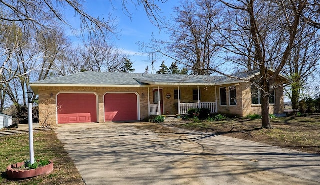 view of front facade with a shingled roof, an attached garage, brick siding, covered porch, and driveway