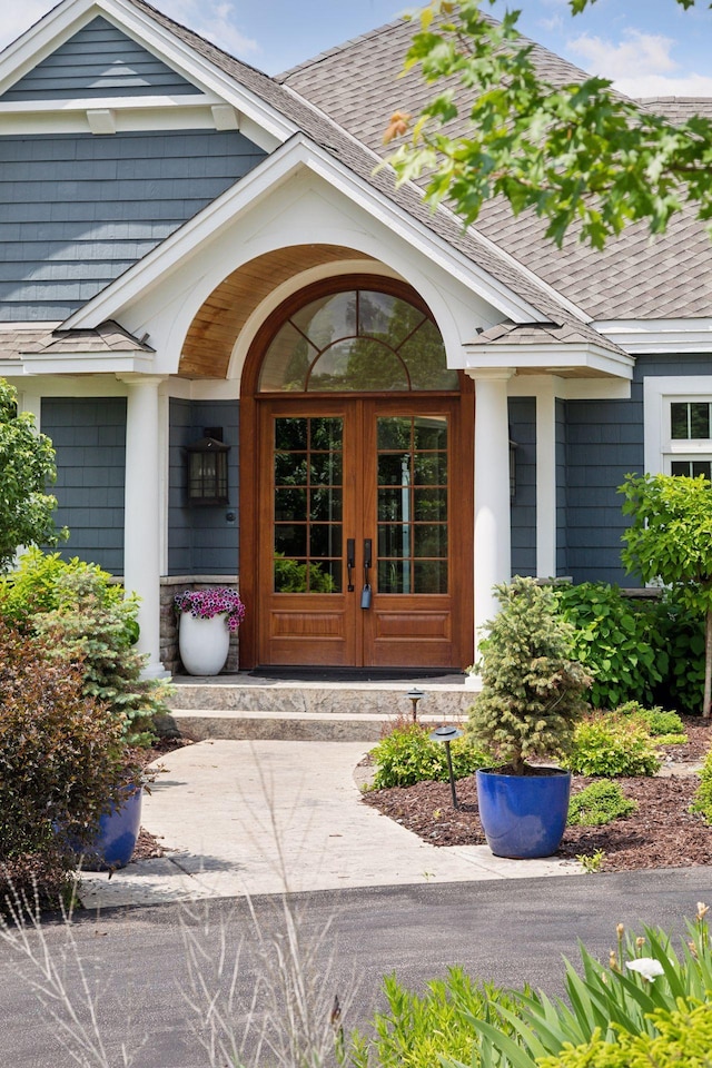 property entrance featuring french doors and a shingled roof