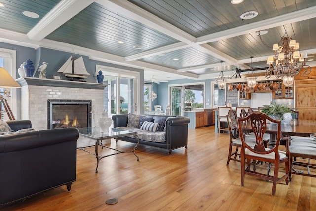 living room with wood ceiling, a brick fireplace, beamed ceiling, light wood-style floors, and recessed lighting
