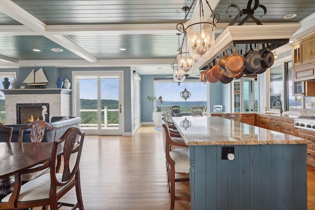kitchen featuring a kitchen breakfast bar, light stone countertops, wood finished floors, baseboards, and a chandelier