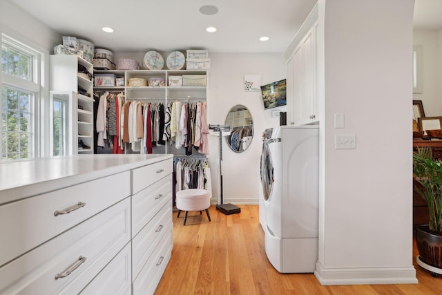 spacious closet with washer / dryer and light wood finished floors