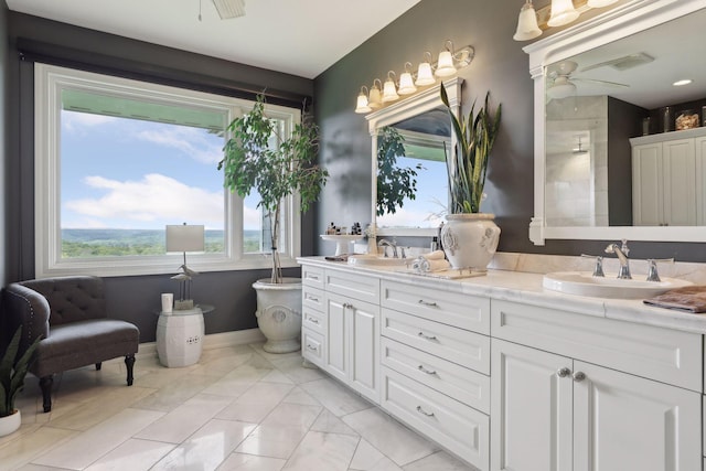 bathroom with a sink, baseboards, ceiling fan, and double vanity