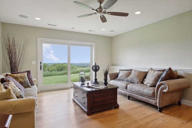 living area with a ceiling fan, visible vents, and light wood-style floors