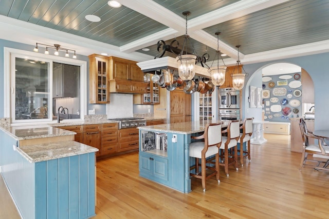 kitchen featuring a kitchen bar, arched walkways, a center island, beam ceiling, and an inviting chandelier