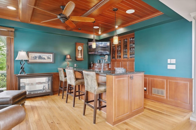 bar with crown molding, wet bar, light wood-type flooring, visible vents, and wood ceiling
