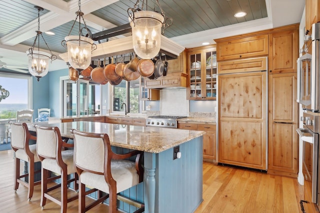 kitchen with an inviting chandelier, light wood-type flooring, a wealth of natural light, and oven