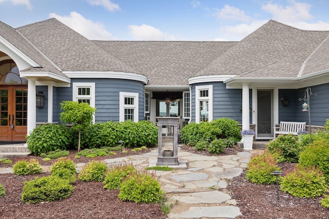 property entrance featuring french doors and roof with shingles