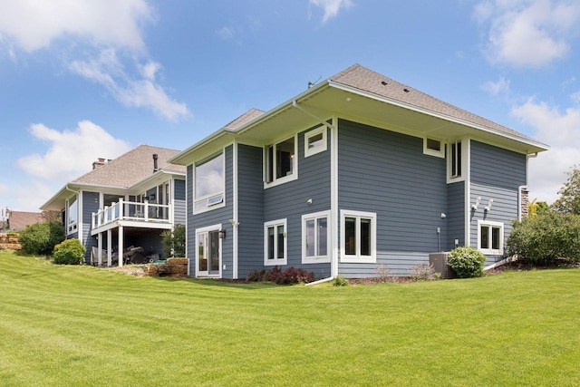 rear view of house with a lawn and central air condition unit