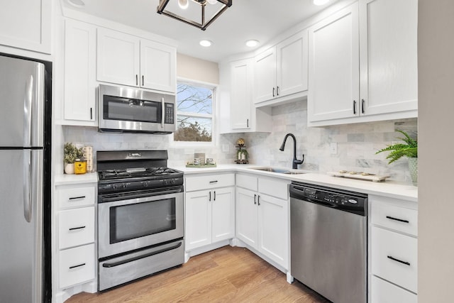 kitchen with white cabinetry, a sink, and stainless steel appliances