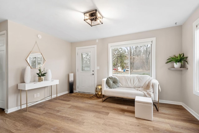 sitting room with baseboards and light wood-style floors
