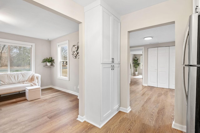 hall featuring baseboards and light wood finished floors