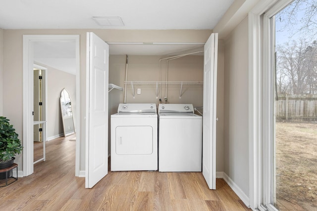 washroom with baseboards, laundry area, separate washer and dryer, and light wood finished floors