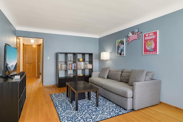 living room featuring baseboards and light wood-style flooring