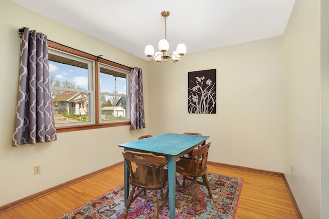 dining room featuring baseboards, a chandelier, and wood finished floors